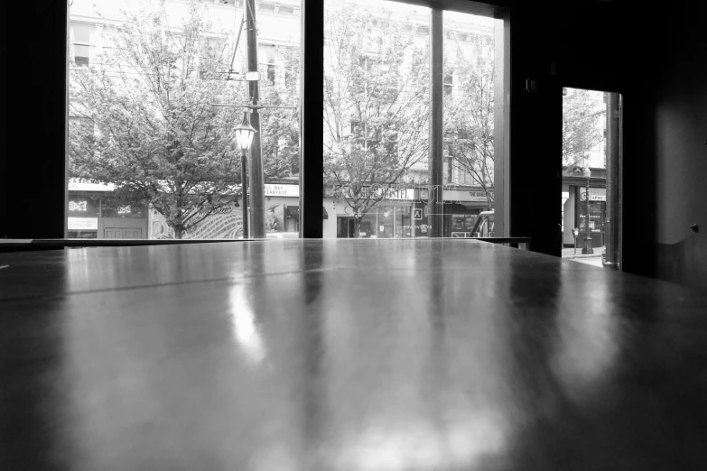 large windows in a dark room with wooden tables and benches