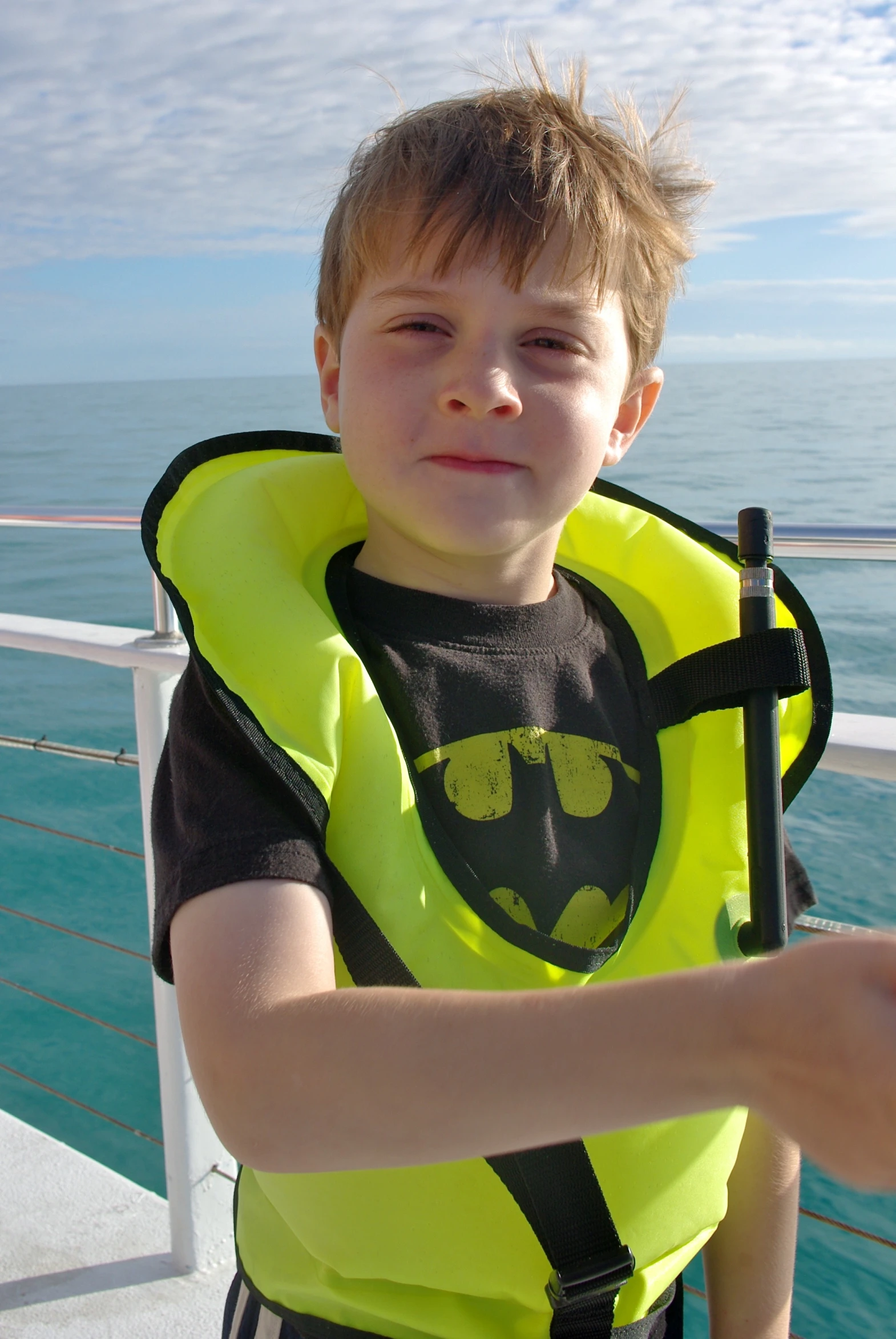 a boy in a life jacket on a cruise ship