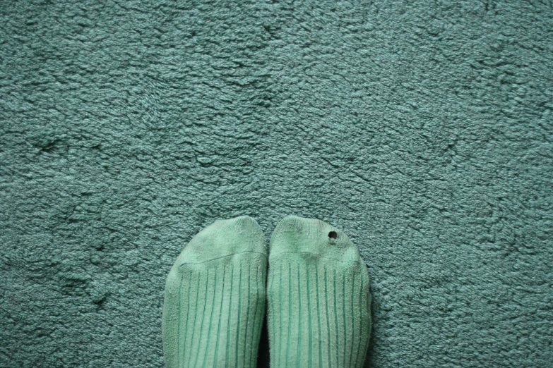 someone's feet on the green area rug