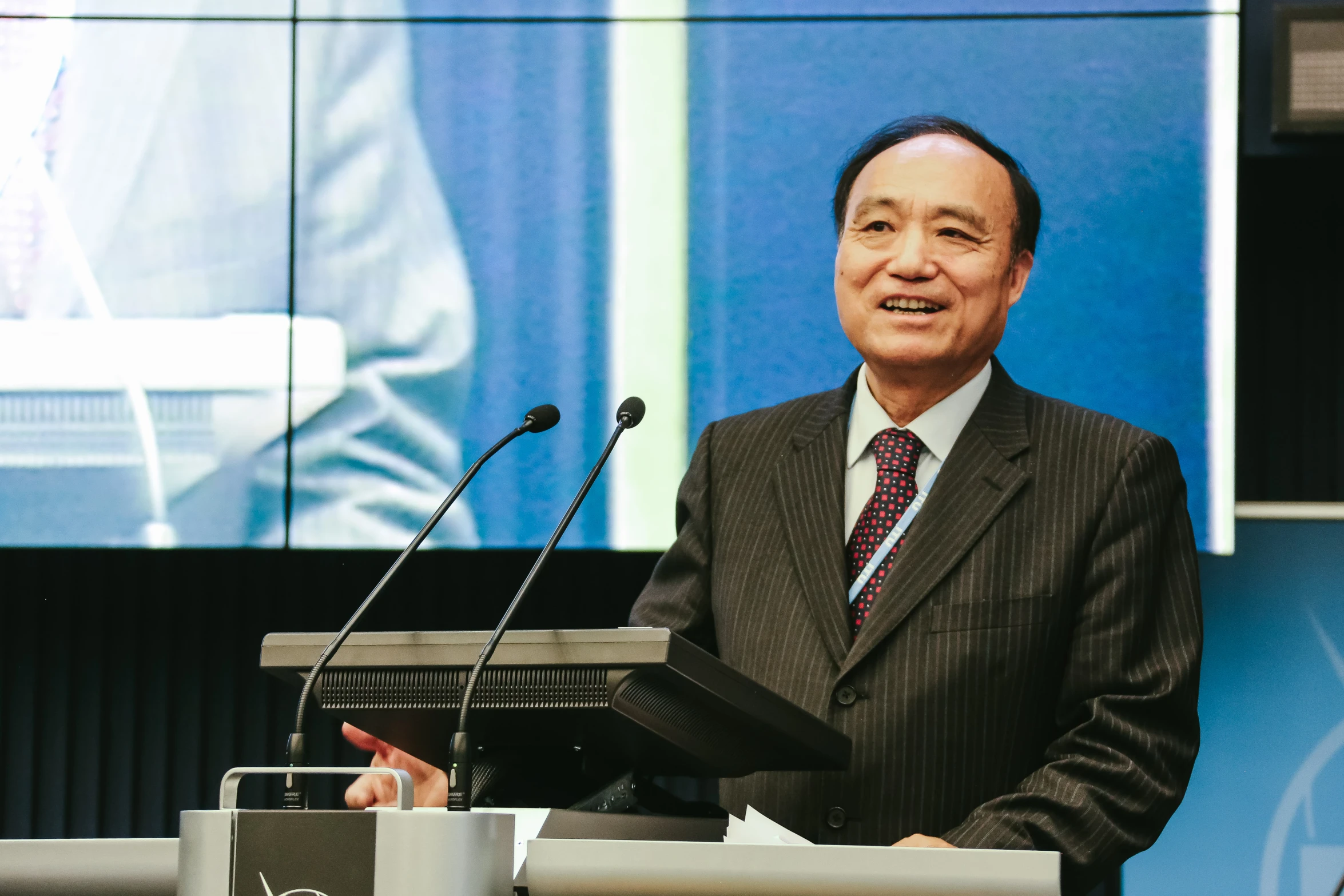 a man standing in front of a podium with microphones