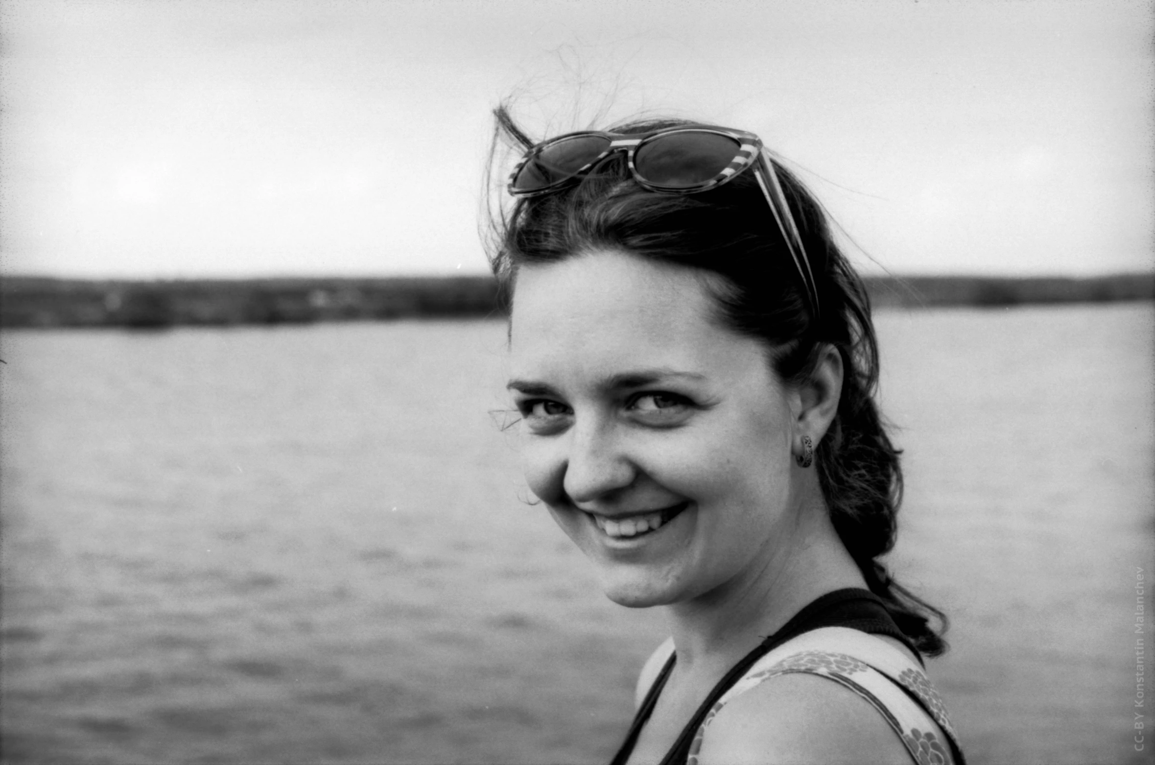 a woman smiling wearing sunglasses on a boat