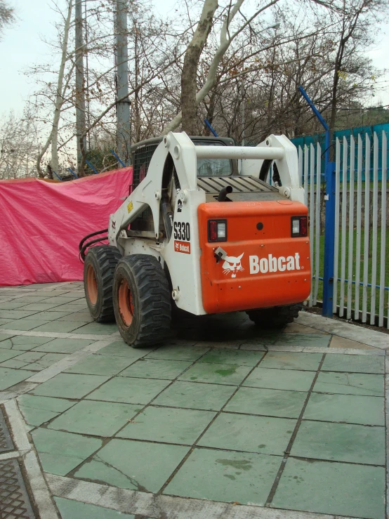 the bullcat truck is parked on the sidewalk next to a fence