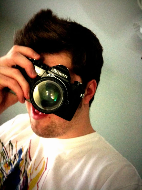 man taking a picture in front of a mirror with his camera