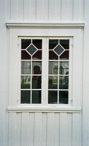 two windows in the side of a white house
