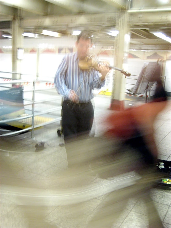 man playing violin on city street at night