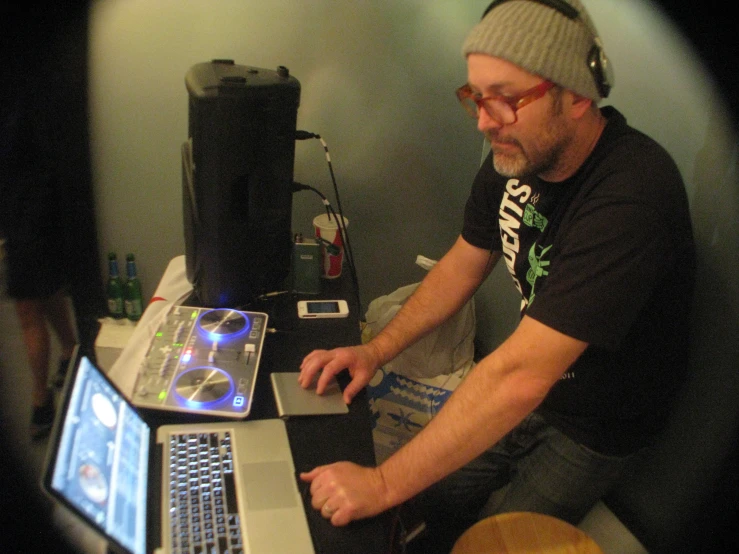 a man sits at a laptop with the laptop screen on his lap