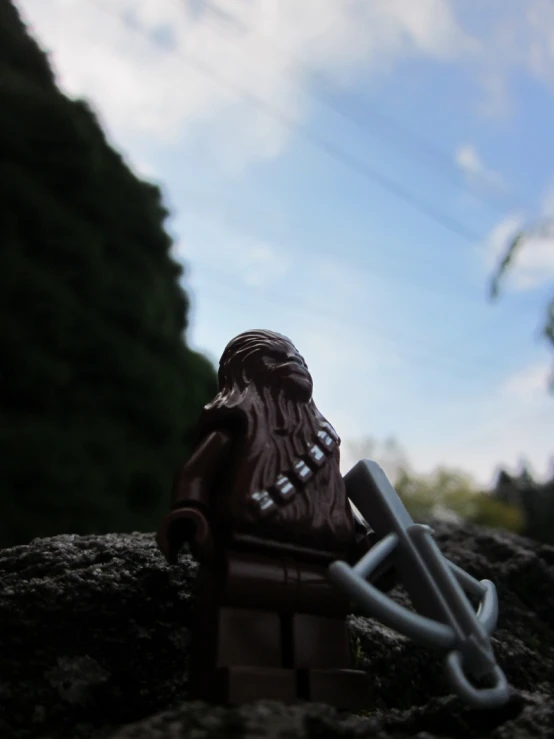 a lego man with dark hair and a mustache standing in a field