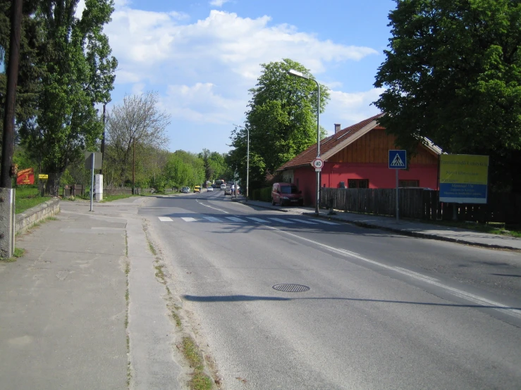 an empty street with a red building on the corner