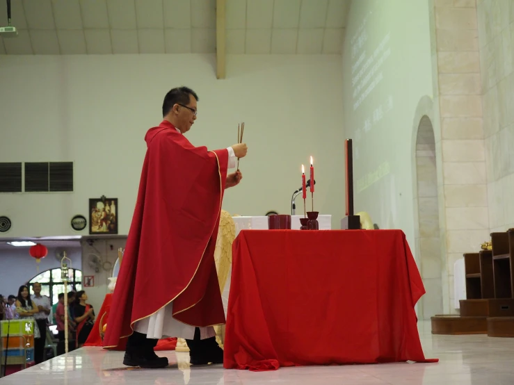 priest putting the candles inside of the church