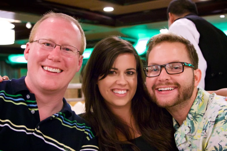 a couple and a lady are smiling at the camera