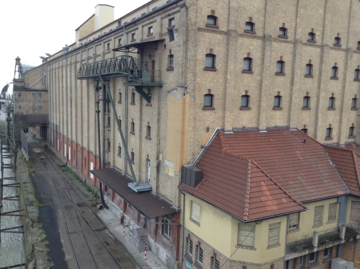 an overhead view of a building with a train track on one side and a train on the other