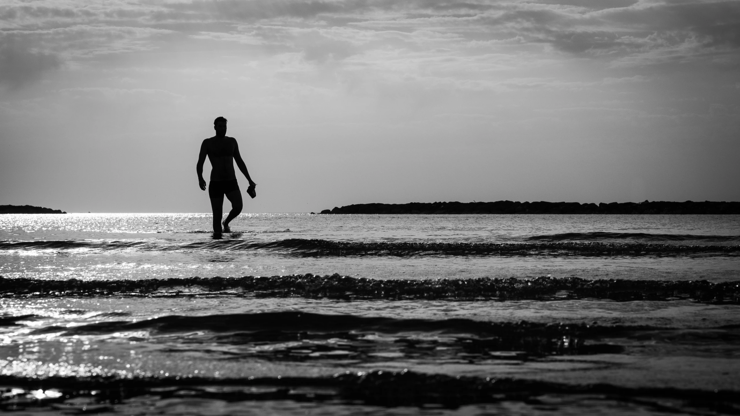 the silhouette of a man in the water