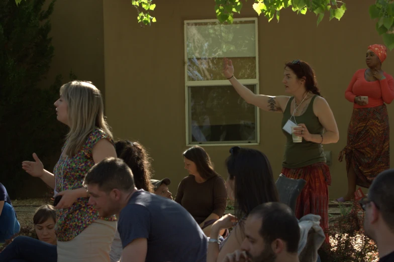 several people at an outside gathering with one pointing