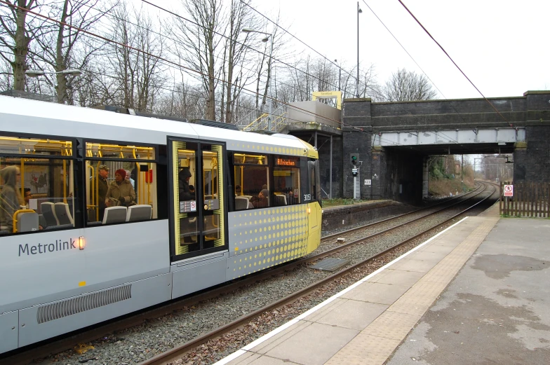 a long white and yellow train at a platform
