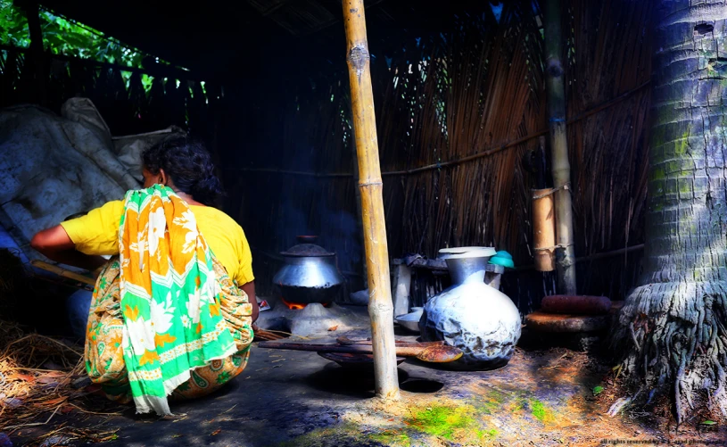 a woman sits in a hut with several pots