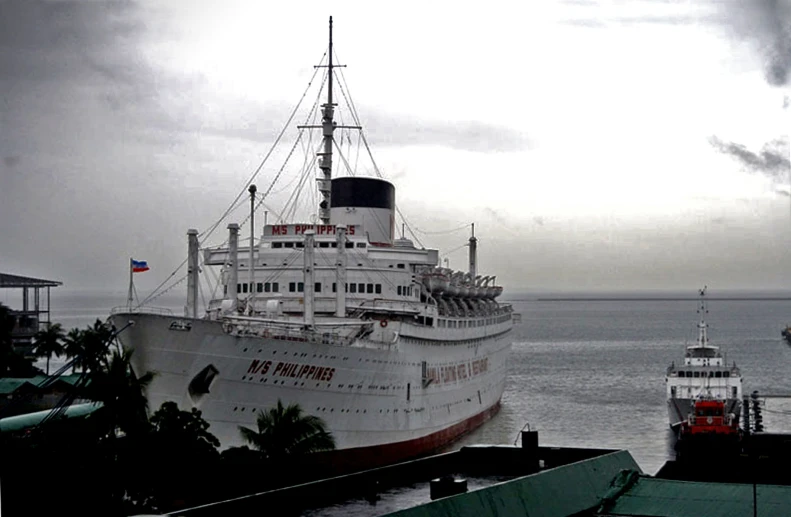 a large boat sitting near other boats on the water