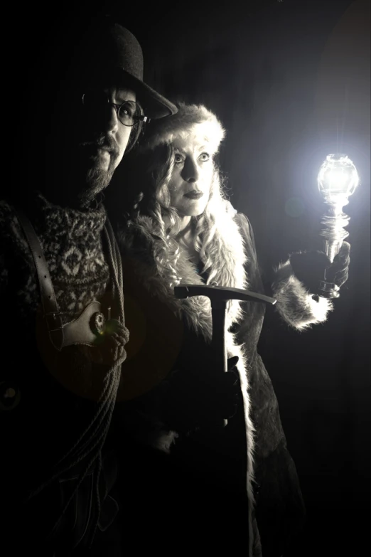 two people wearing christmas costumes one holding a lamp