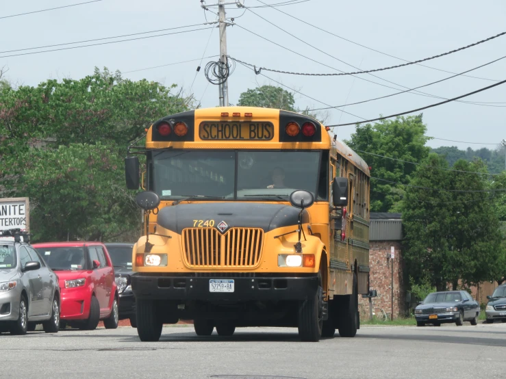 a bus is driving down a road next to parked cars