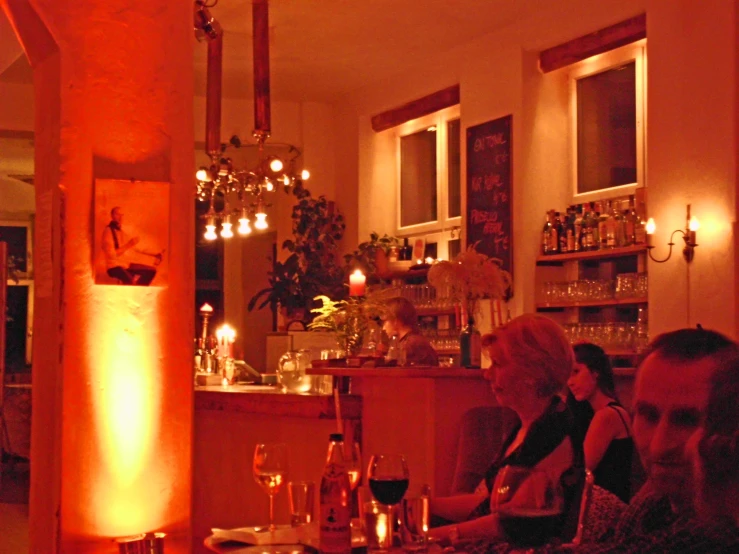 three people in a dimly lit, darkened restaurant