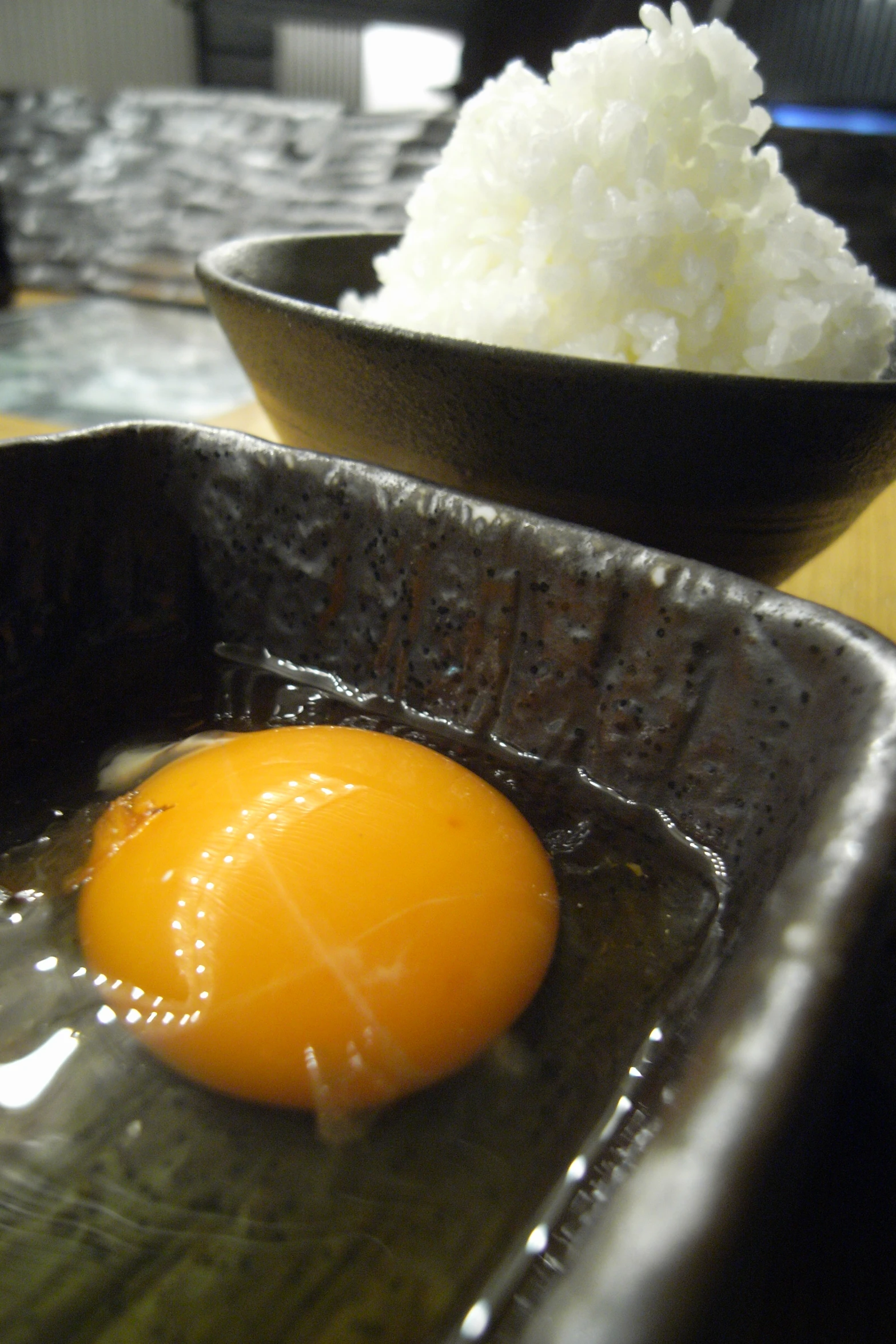 a cooked egg on a plate near a bowl of rice