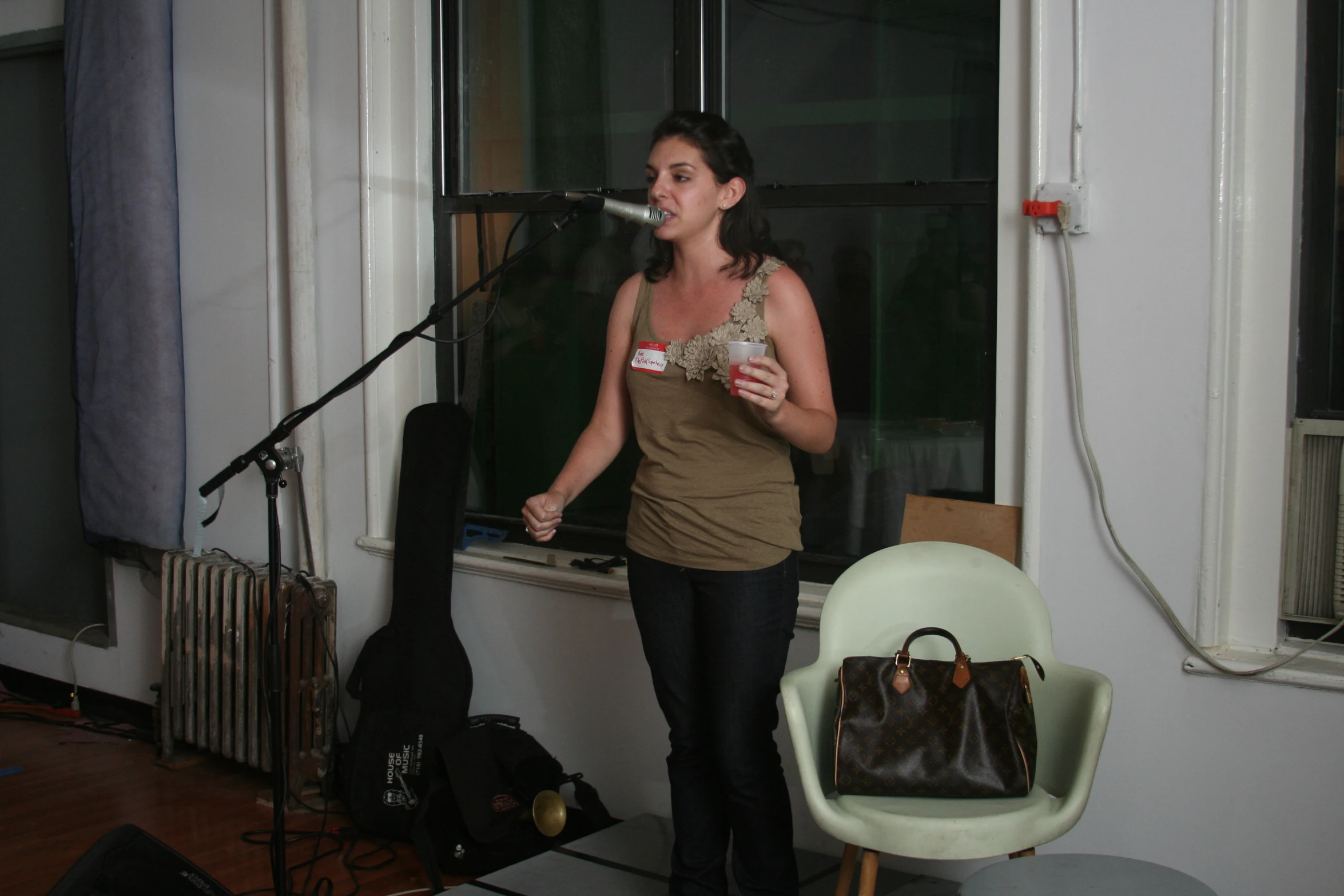 a woman standing in front of a guitar and microphone