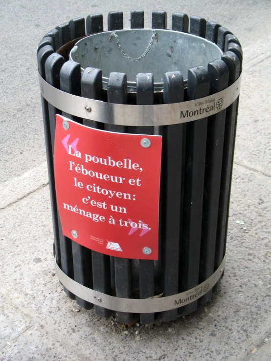 a black trash can with red sign attached to it