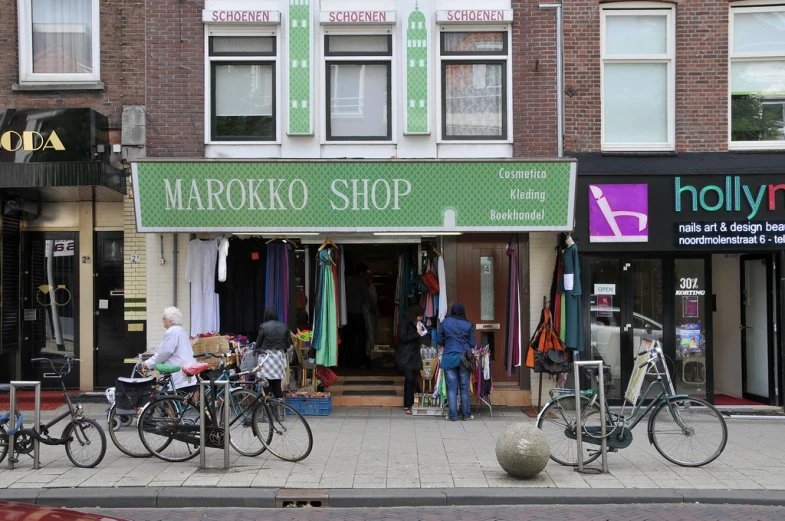 two men standing near bicycles and shop windows