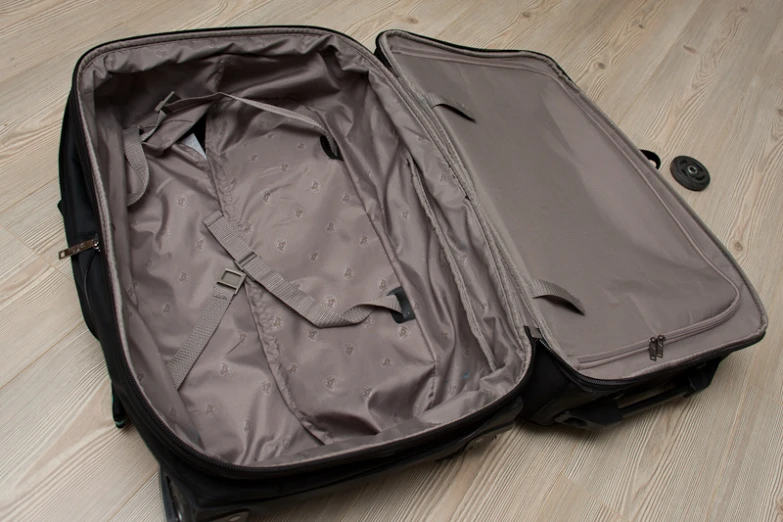 an opened suitcase with handles laying on the floor