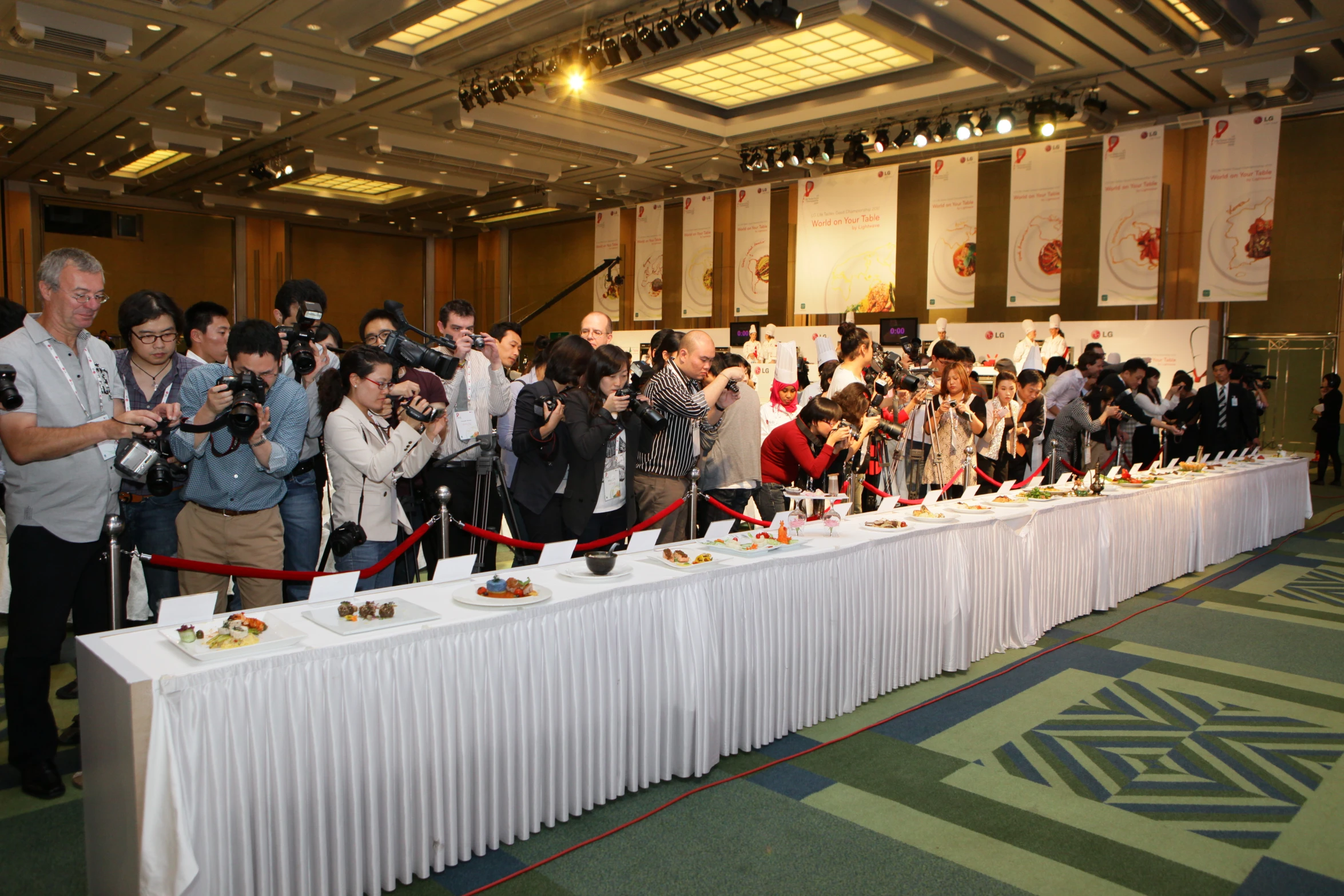 many people standing around eating food while one person is holding a camera