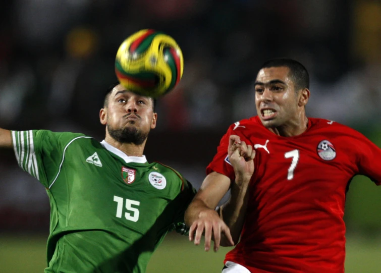 two men playing soccer against each other in the middle of an air