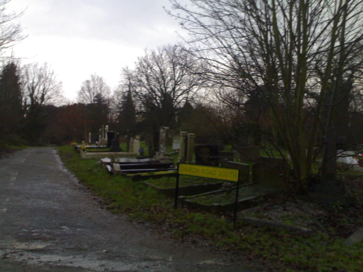 a small cemetery sits on an overgrown country road