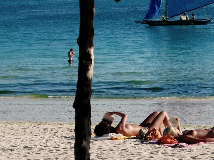 some people are lying on the sand on a beach