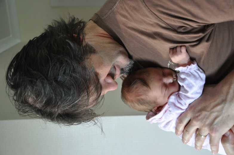 a man in brown shirt holding a small child