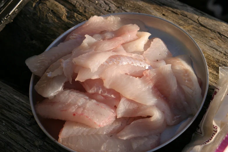 raw fish is displayed on a plate with meat wrappers