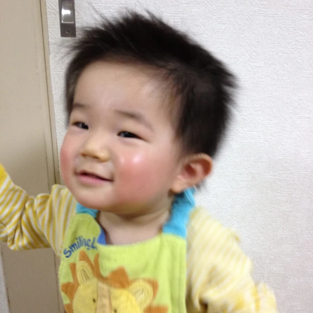 a child smiling and waving at the camera