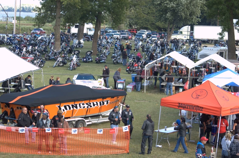 the crowd of people is gathered together near parked motorcycles