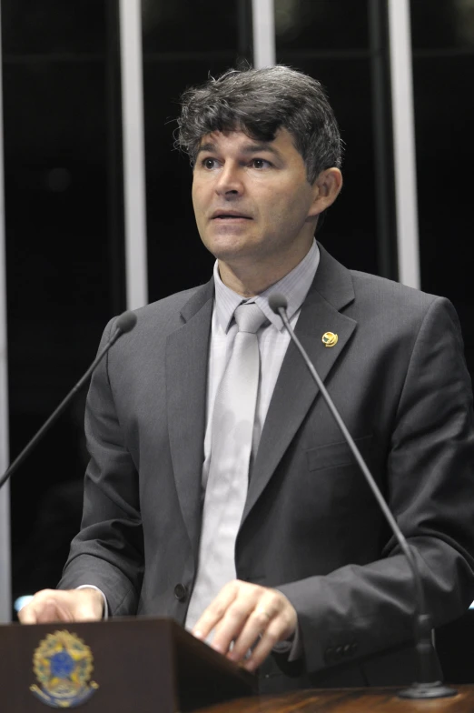 a man stands behind a podium in a suit