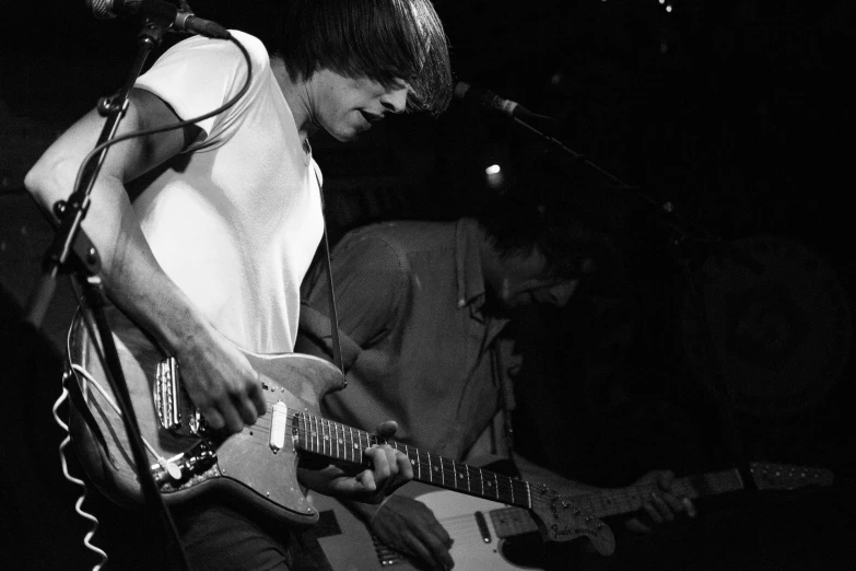 a man that is playing guitar with a microphone