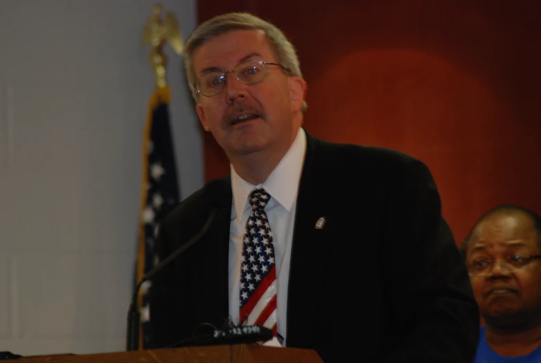 a man stands at a podium making a speech