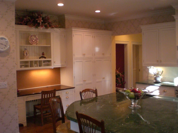 a room that has white cabinets and a green counter top