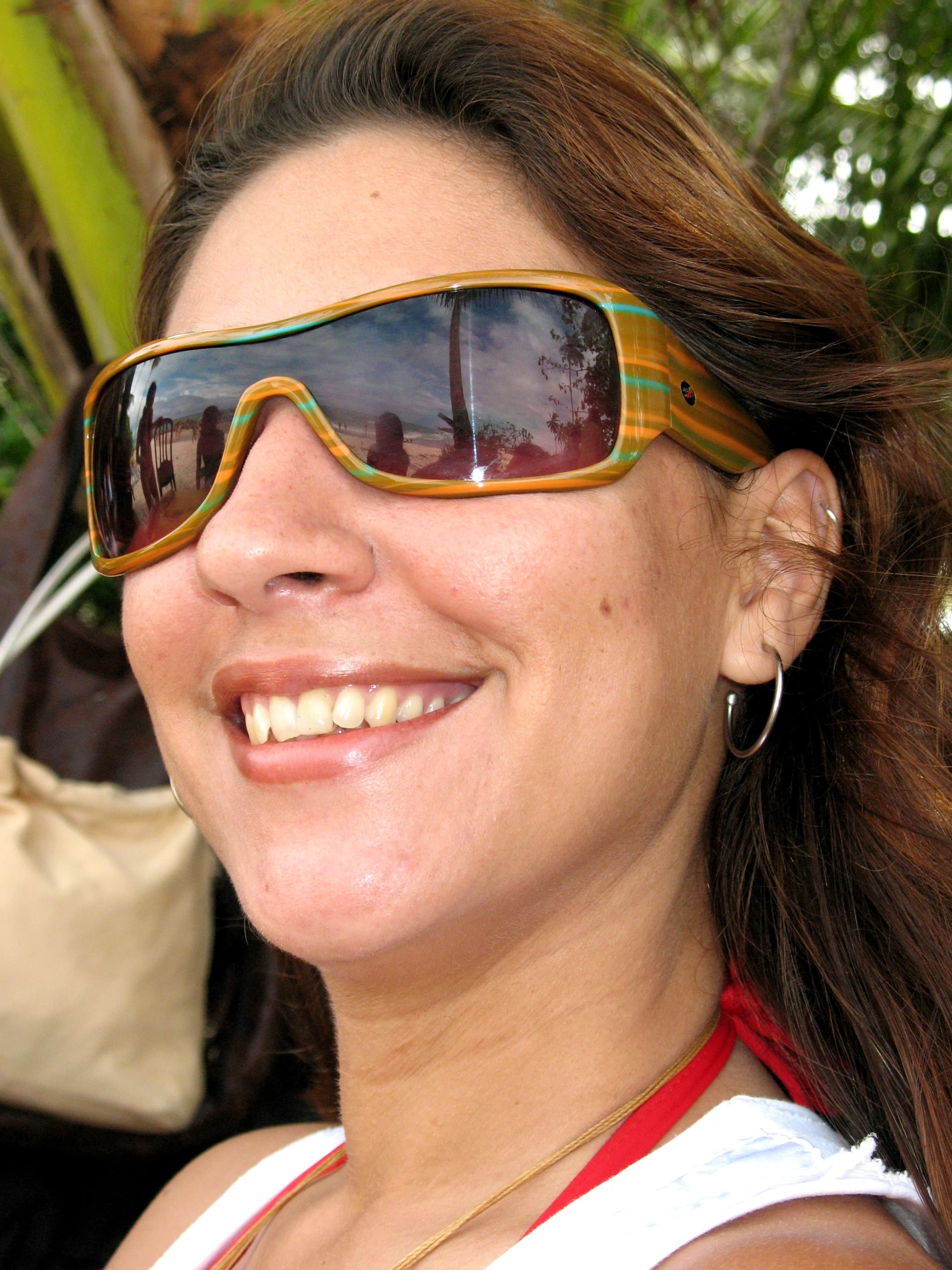 smiling woman wearing sun glasses in outdoor setting