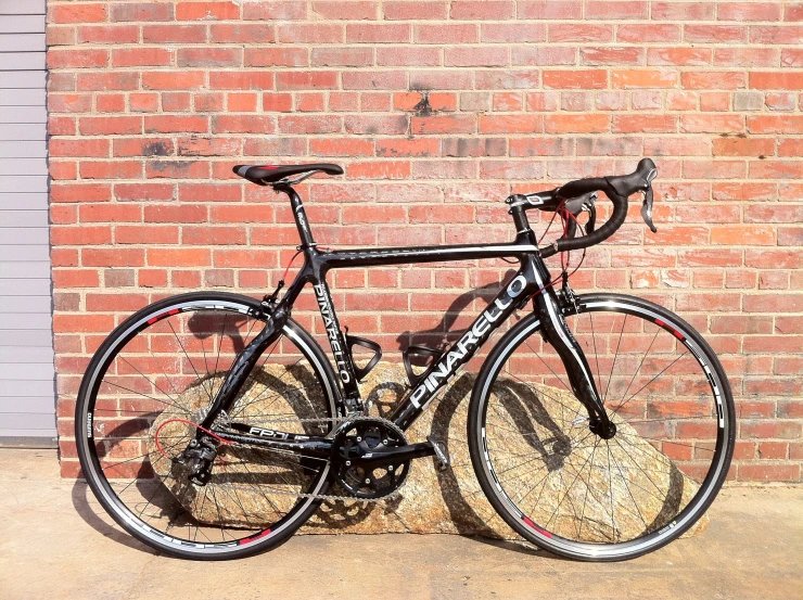 a bike parked against a brick wall in front of a building