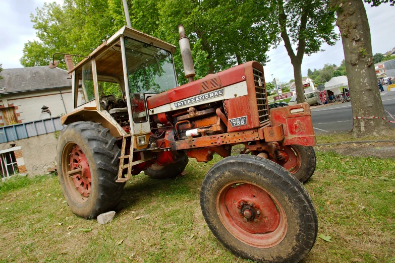 an old red tractor with the hood turned down