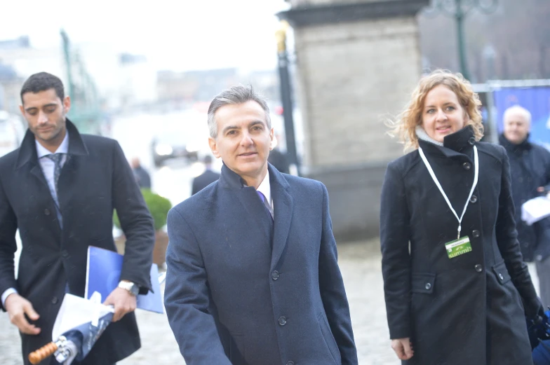 two men and a women with umbrellas walking around