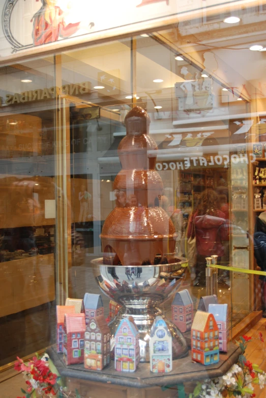 the small model houses are in front of the chocolate fountain