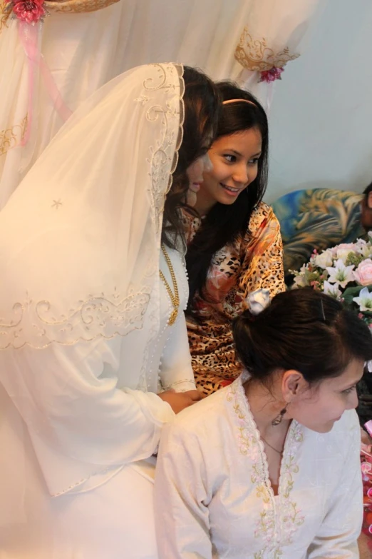 the bride is in front of her friend as she has her hair in a bun