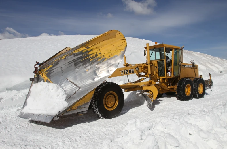 a large yellow and black machine sits in the snow