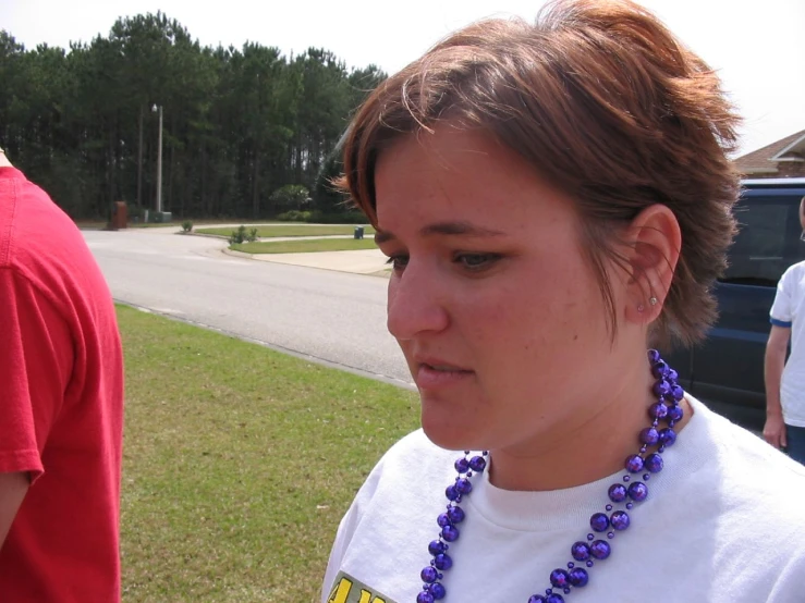 the girl wears a purple necklace with blue beads