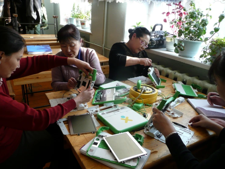 a group of people in a room working on electronic equipment