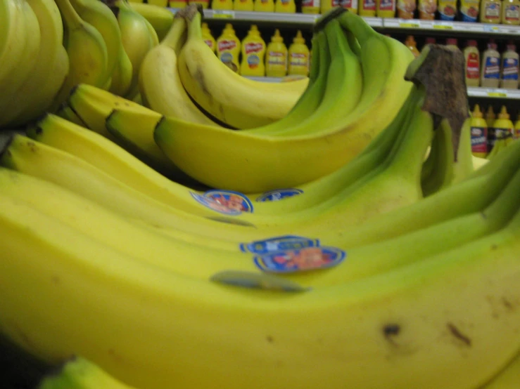 a line of yellow bananas are in a grocery store